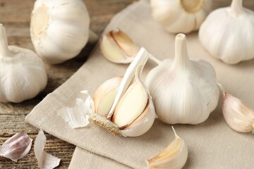 Fresh garlic bulbs and cloves on wooden table, closeup