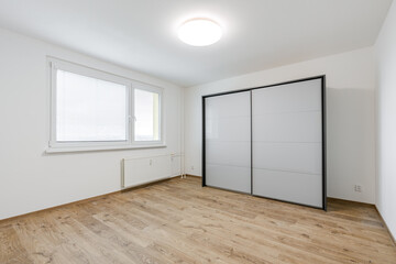 Fototapeta premium Empty modern apartment bedroom with sliding wardrobe and window