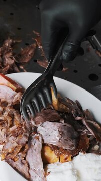 Fresh shawarma on a plate: crispy flatbread, grilled meat, and sauce. Meat being served on top. Close-up, dynamic shot, restaurant kitchen
