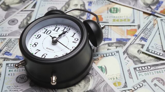 Clock face timelapse on dollar banknotes. Concept of finance and money payment. Time ticking on old fashioned alarm clock with bells. Time moving fast. Table clock show running time. 4K, UHD