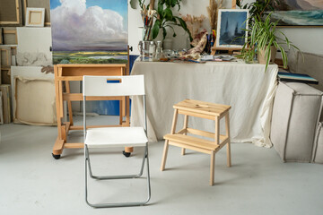 Fototapeta premium Artist studio interior loft gallery with paintings. easel and worktable, creative space for art hobby therapy and relaxation. Modern art workshop with artworks display on walls and creative supplies.