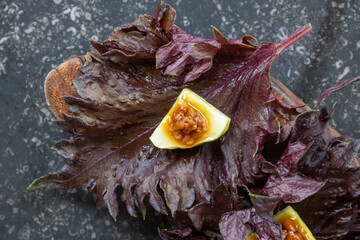 Compliment from chef in restaurant amuse-bouche with purple salad leaves and fruits and nuts