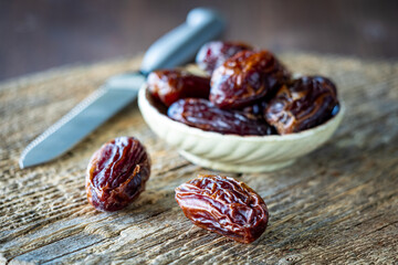 A close up of Medjool dates on a rustic wooden cutting board.