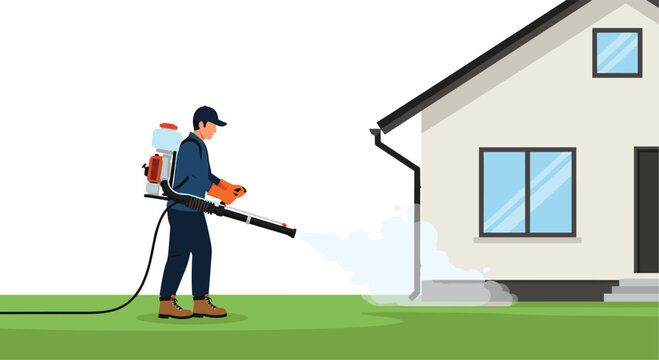 A pest control worker wearing a cap and gloves is spraying insecticide around the foundation of a house with a backpack sprayer.