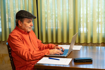 Senior man working on laptop at home