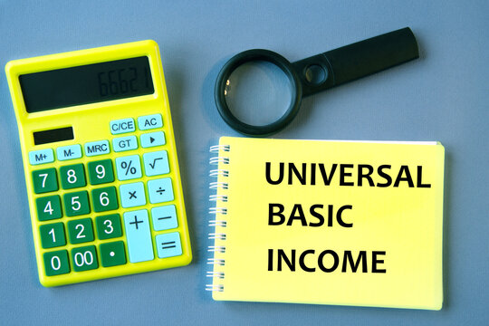 UNIVERSAL BASIC INCOME - words on wooden colored blocks against a calculator background