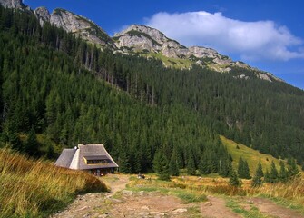 Mountain shelter in the Tatra Mountains. Rocky peaks and green slopes create a majestic backdrop for the traditional architecture. © puchan