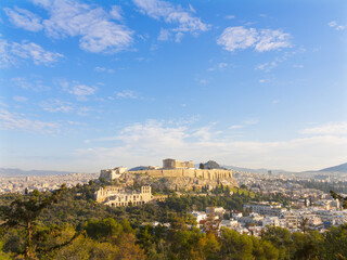 Obraz premium Ancient Acropolis citadel overlooking Athens cityscape under blue sky with scattered clouds