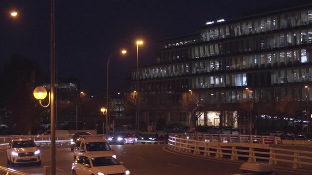 A busy street with cars and a tall building in the background