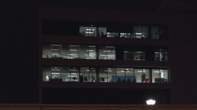 A tall building with many windows lit up at night