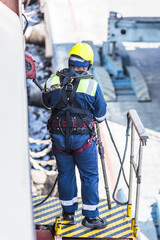 Seafarer in protective gear preparing a gangway after docking to ensure safe access to the vessel.