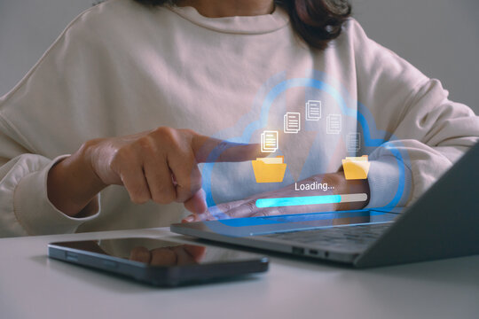 Cloud computing and data storage concept. Businesswoman uploading files on laptop computer. Online backup, digital document management, secure file transfer and modern business technology workflow.