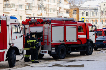 Fireman in uniform near fire truck preparing for fire extinguishing
