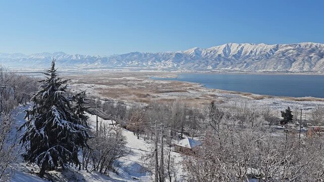 Winter lake surrounded by snowy trees and Zagros mountains under a clear blue sky, creating a peaceful and scenic natural landscape.  
📍Zaribar lake, Marivan