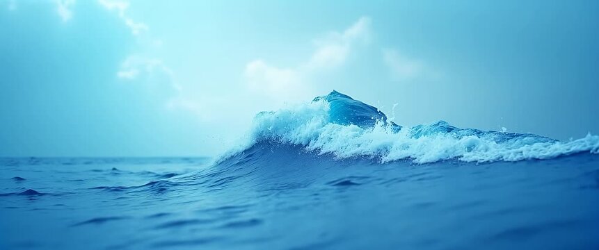 Serene ocean waves gently rise and fall, captured in a slow cinematic pan as soft clouds drift across the blue sky, creating a tranquil and inspiring seascape.