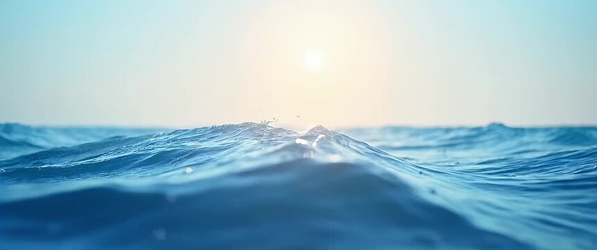 Sunlit ocean waves gently crest and fall, with a slow cinematic pan capturing the serene horizon and flickering sunlight, perfect for stock footage on relaxation and nature.