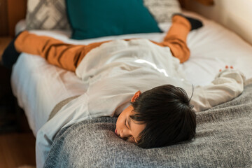 Child/boy lying on bed (villa/cottage/family trip)