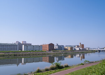 Obraz premium 川沿いに並ぶ街並みと水面の反射