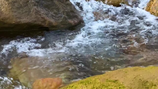 Natural stream river flowing over rocks, clear clean shallow water in Bangladesh
