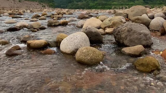 Shallow stream of water mountain cold river with pebble stones in Bangladesh valley