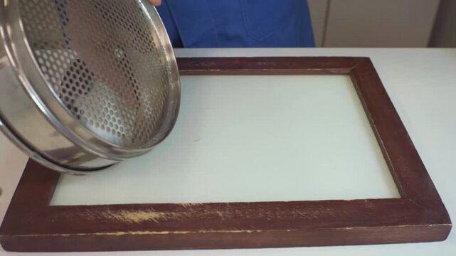 A laboratory technician sweeps up foreign matter found in wheat to determine its weight. Technical analysis of grains. Grain laboratory.
