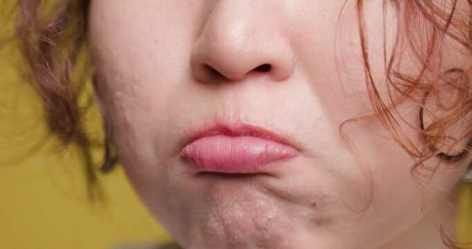 Close-up of a young woman making a funny face, detailed shot of lips and facial expression
