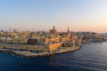 Fototapeta premium Fortified waterfront and skyline at sunset - Valletta, Malta