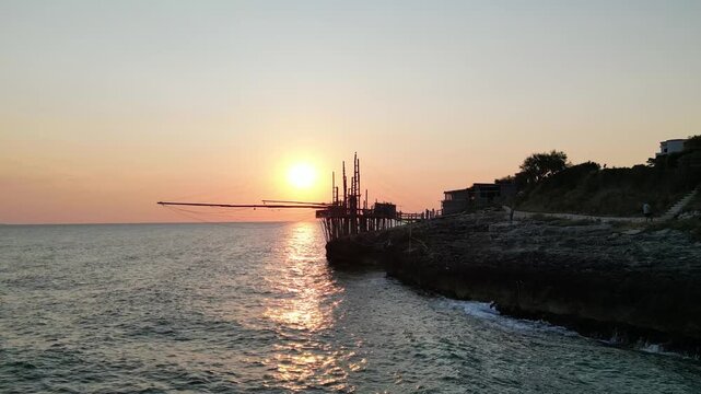 trabucco antico all'alba sulla costa rocciosa del Gargano in Puglia
