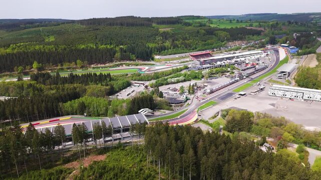 belgium f1 formula one circuit spa francorchamps eau rouge section by pit paddock complex racing asphalt run off zones grandstands forest rolling hills area 