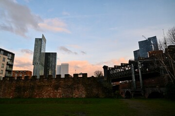 Roman fort wall and modern buildings in Castlefield, Manchester, UK