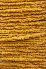 Close-up texture of golden-yellow wool yarn