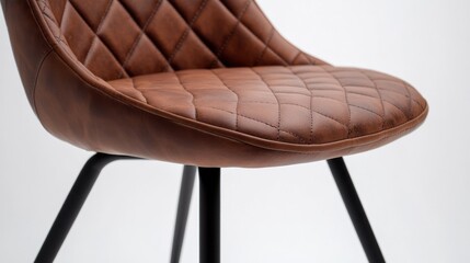 Obraz premium Close-up of a brown leather chair with a quilted design on a white background