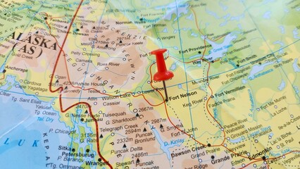 Fototapeta premium View of Fort Nelson, Human settlement in British Columbia, Canada, on a geographical map of America, marked with red push pin