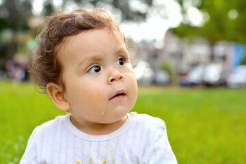Latin toddler looking away with opened mouth and some saliva coming out. 