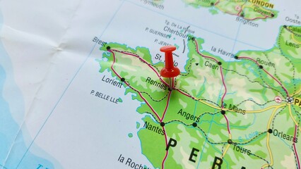 View of Rennes, Capital city of the region of Brittany, France, on a geographical map of Europe, marked with red push pin © PinkyEn
