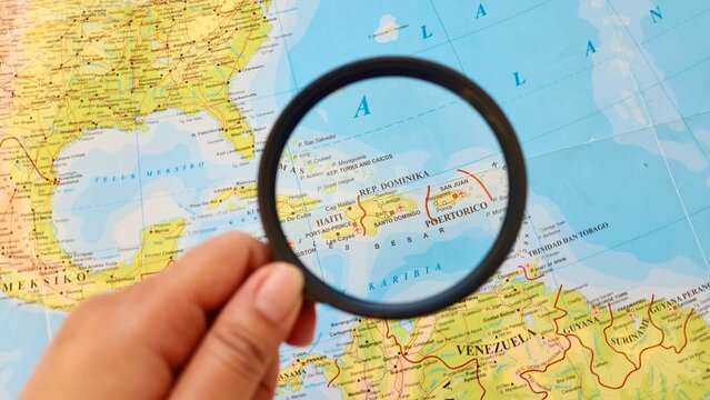 View of The Dominican Republic, is a country located on the island of Hispaniola in the Greater Antilles of the Caribbean Sea, on a geographical map of America, seen using a magnifying glass