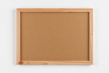 Empty Corkboard with Wooden Frame Hanging on White Wall