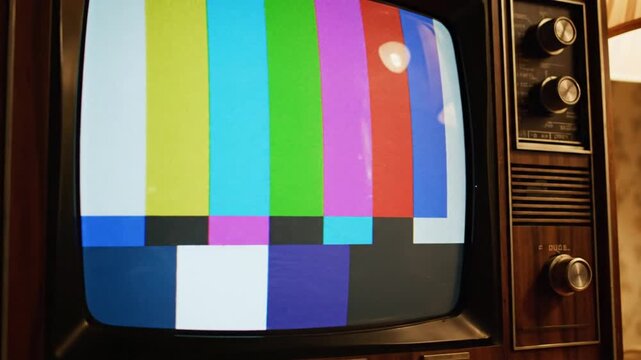 Vintage television with color bar test pattern on wooden table