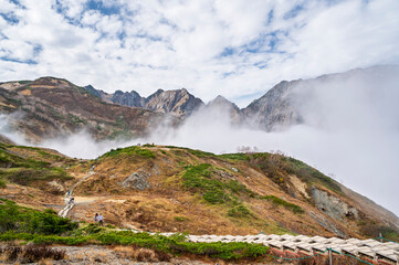 Hiking Route to Happo Pond and  the Japanese Alps mountains landscape with mist background on Hakuba Happo One in Hakuba, Nagano, Japan