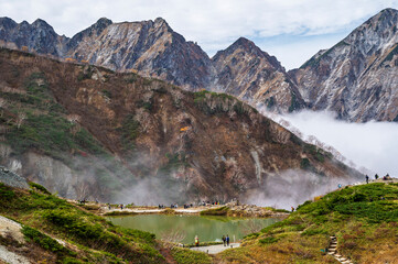 Hiking Route to Happo Pond and  the Japanese Alps mountains landscape with mist background on Hakuba Happo One in Hakuba, Nagano, Japan