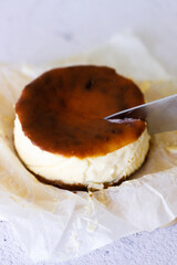 Cheesecake with baking paper on white marble table.