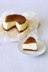 Cheesecake with baking paper on white marble table.