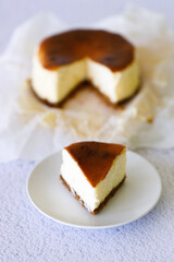 Cheesecake with baking paper on white marble table.