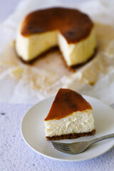 Cheesecake with baking paper on white marble table.