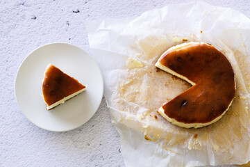 Cheesecake with baking paper on white marble table.