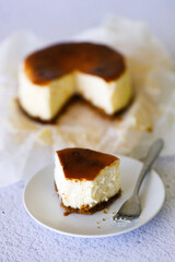 Cheesecake with baking paper on white marble table.