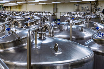Stainless vertical steel tanks and pipes with pressure meter in equipment tank chemical cellar at...