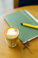 Cup of coffee latte art on wood table.