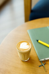Cup of coffee latte art on wood table.