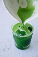 Iced matcha drink with water in a glass.